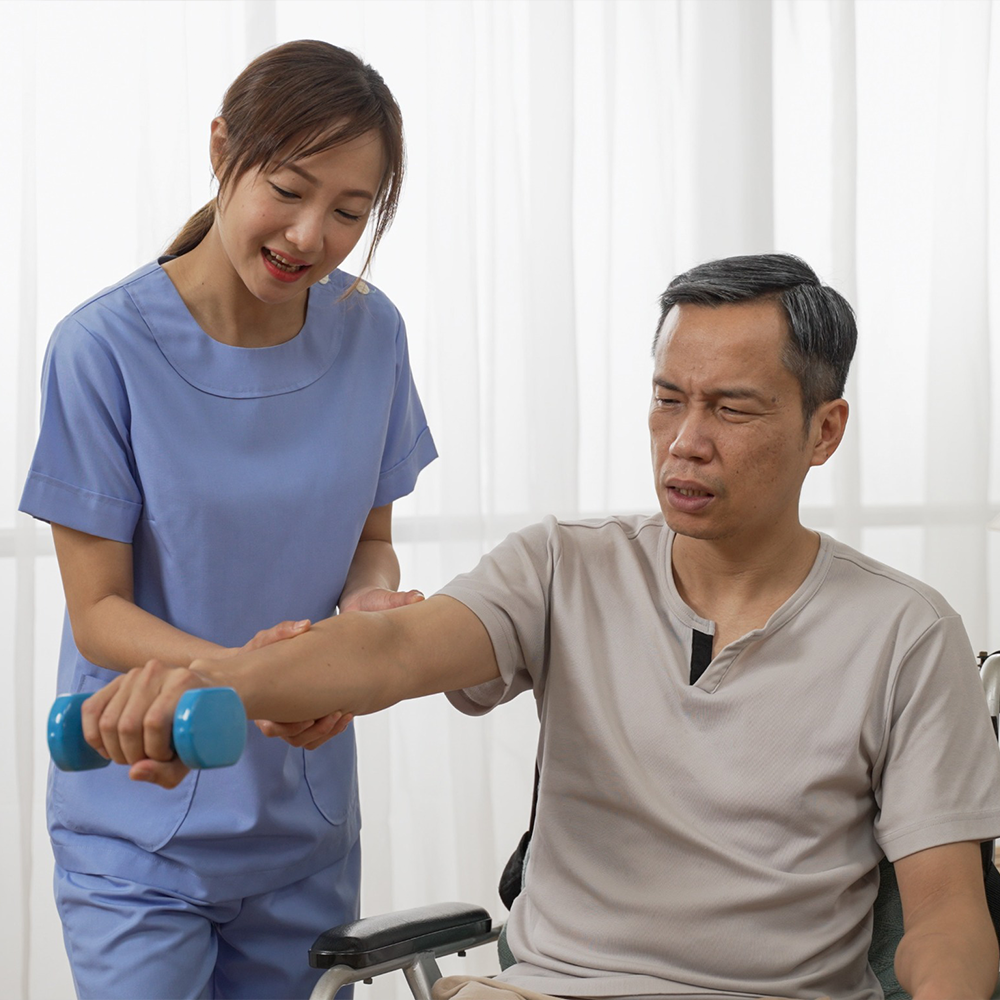 Female nurse helping a male patient lift weights